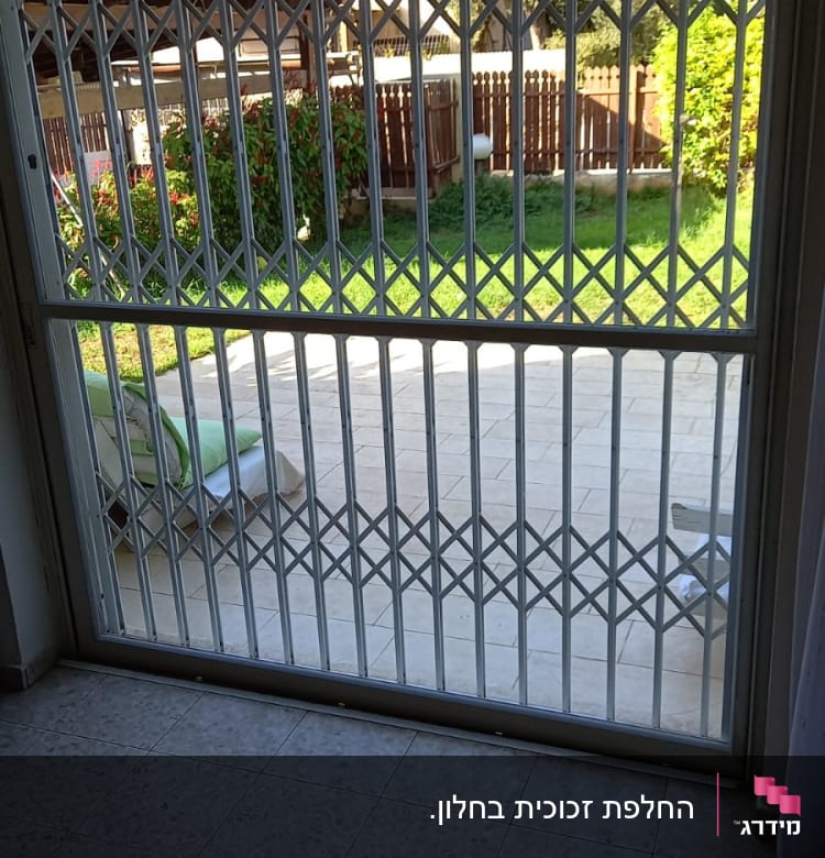 חלון זכוכית עם סורג מתכת נפתח לחצר